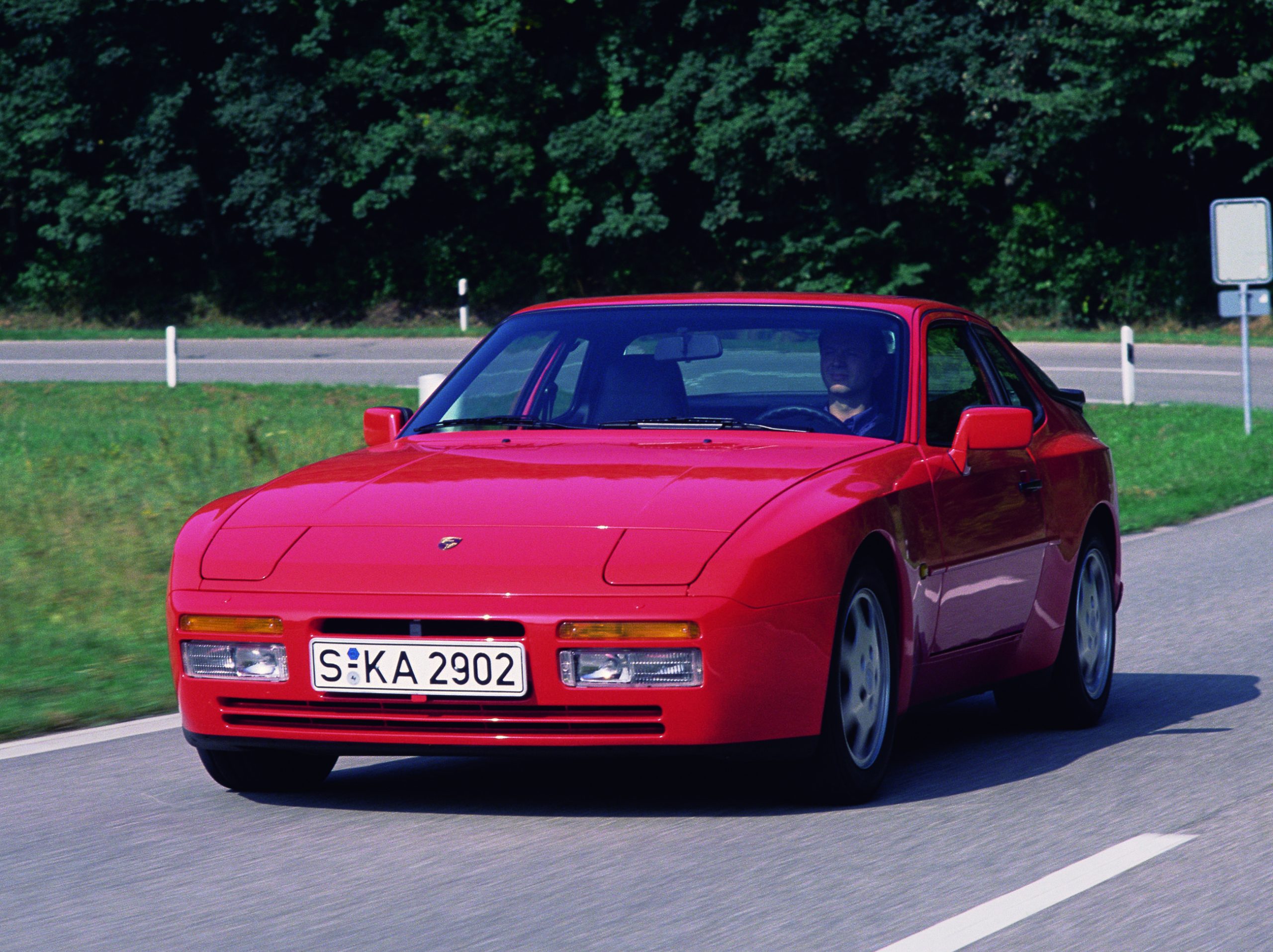 Image of classic red Porsche 944 driving on road