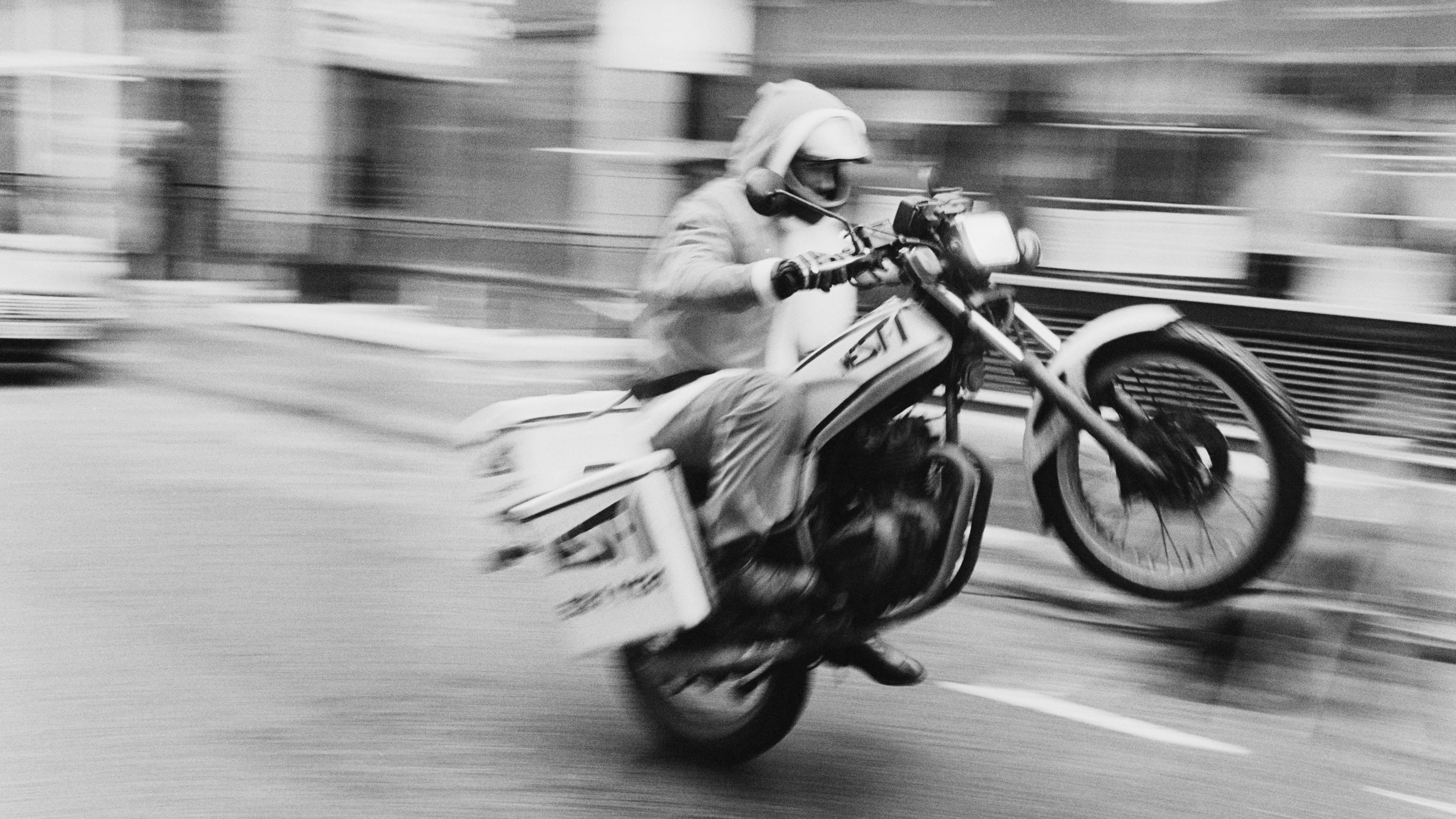 Hill worked as a motorcycle courier to fund his early career. Here the 23-year-old is caught doing a wheelie, December 1983.
