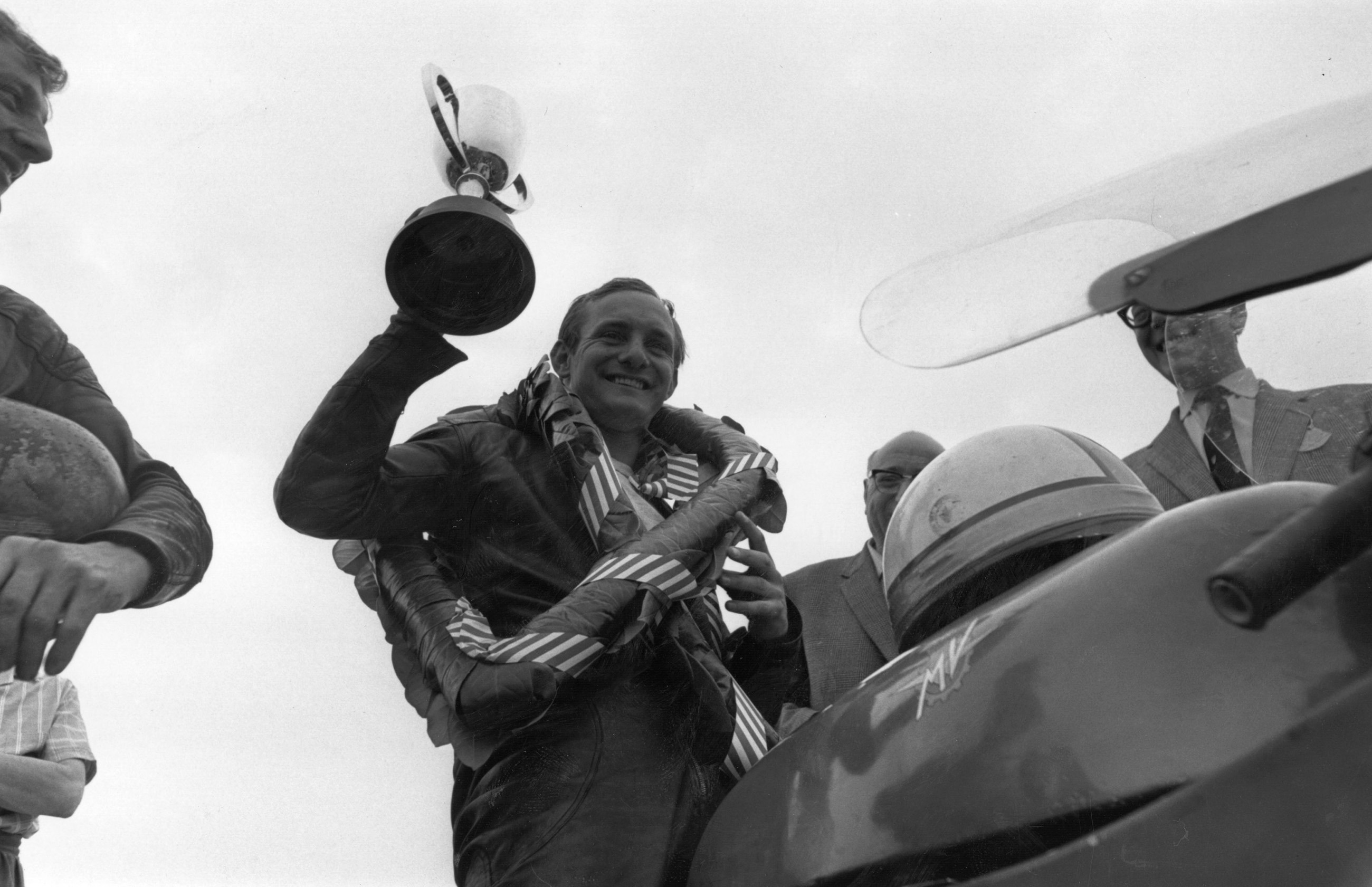 Hailwood, still astride his MV Agusta, lifts the winners trophy after another triumph at Silverstone.