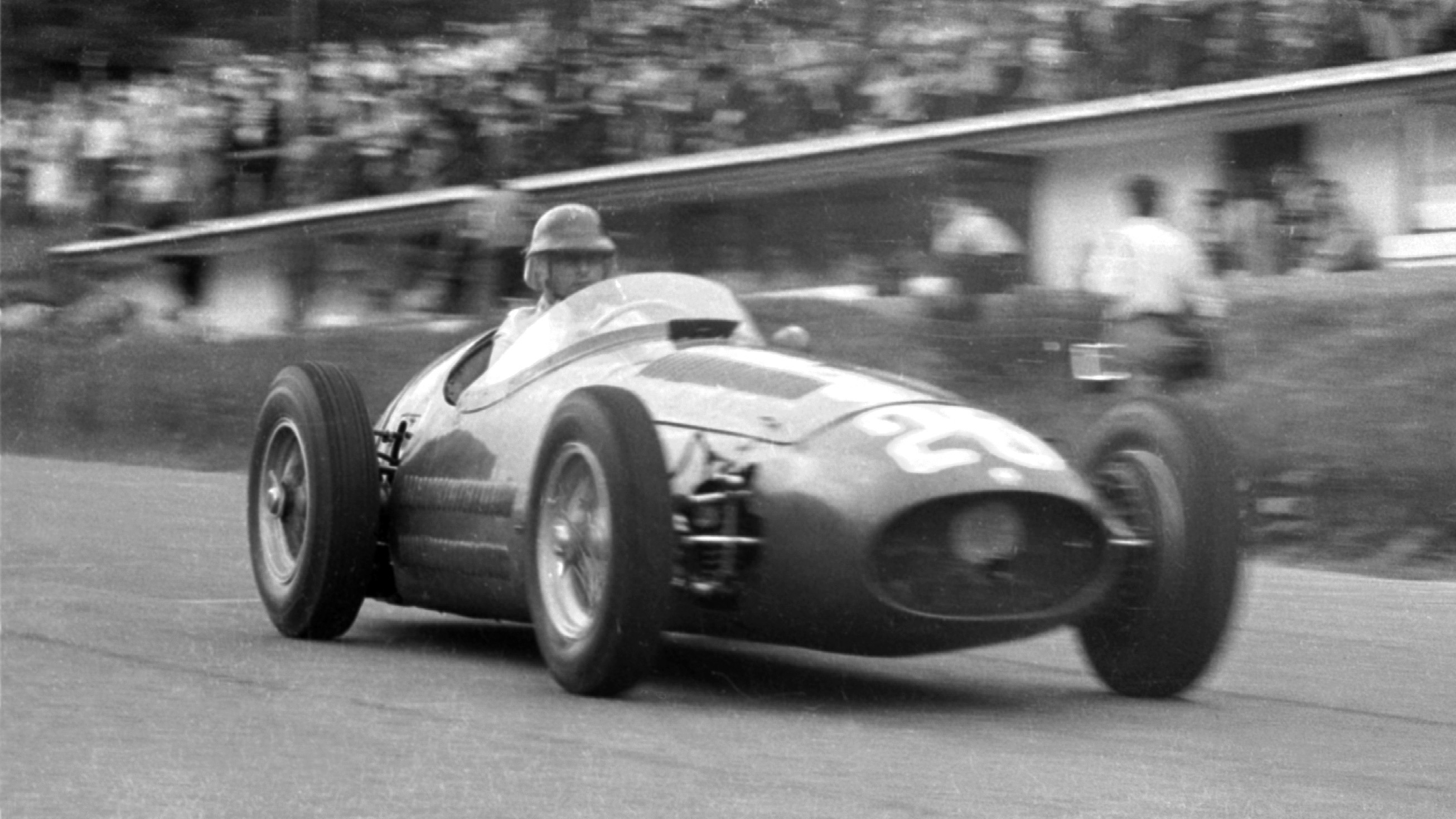 Juan Manuel Fangio races past the pits at Spa-Francorchamps in the Maserati 250F, June 1954.