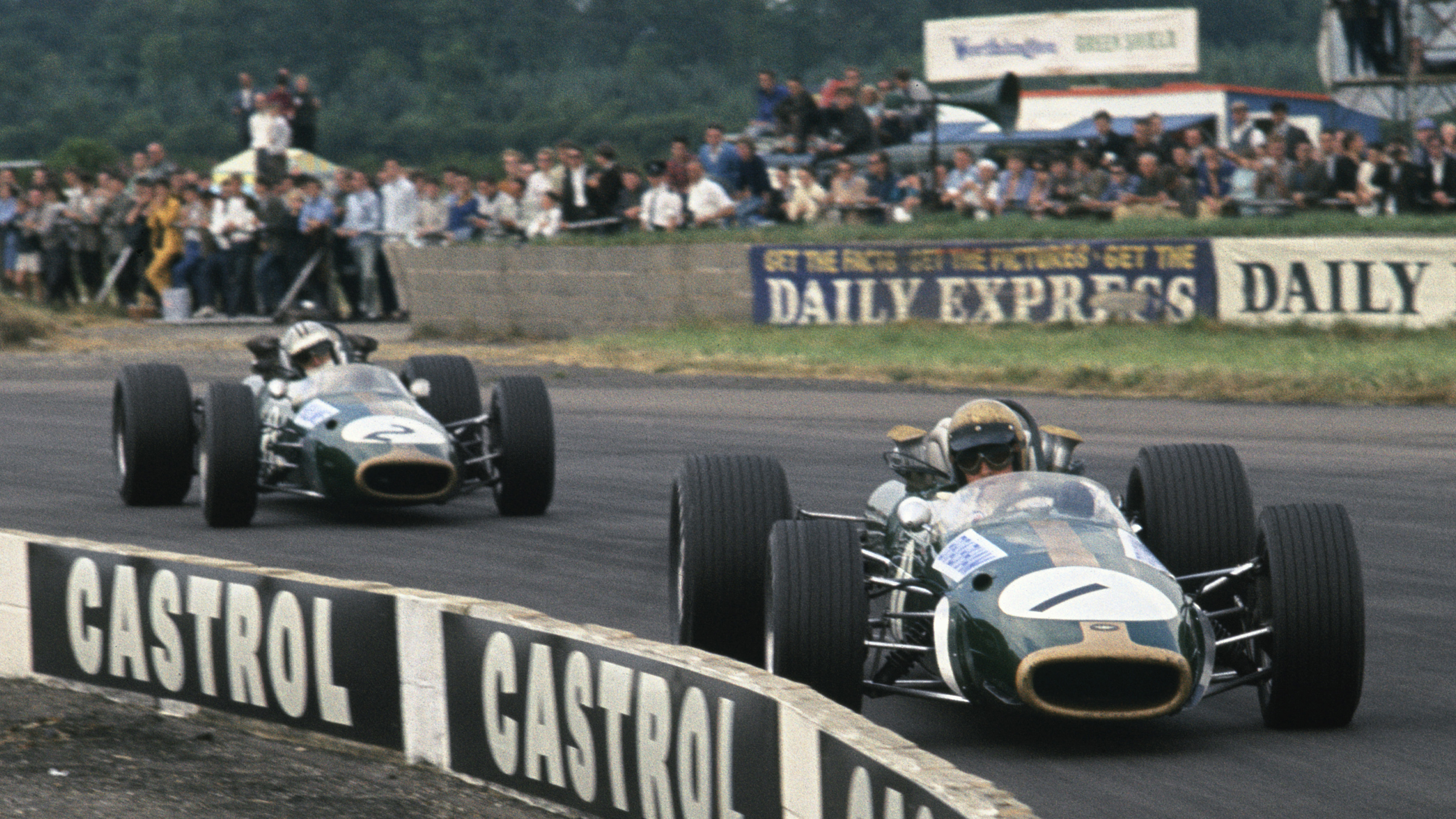Brabham leads team-mate Denny Hulme, both driving Brabham BT24s, at the 1967 British Grand Prix. 