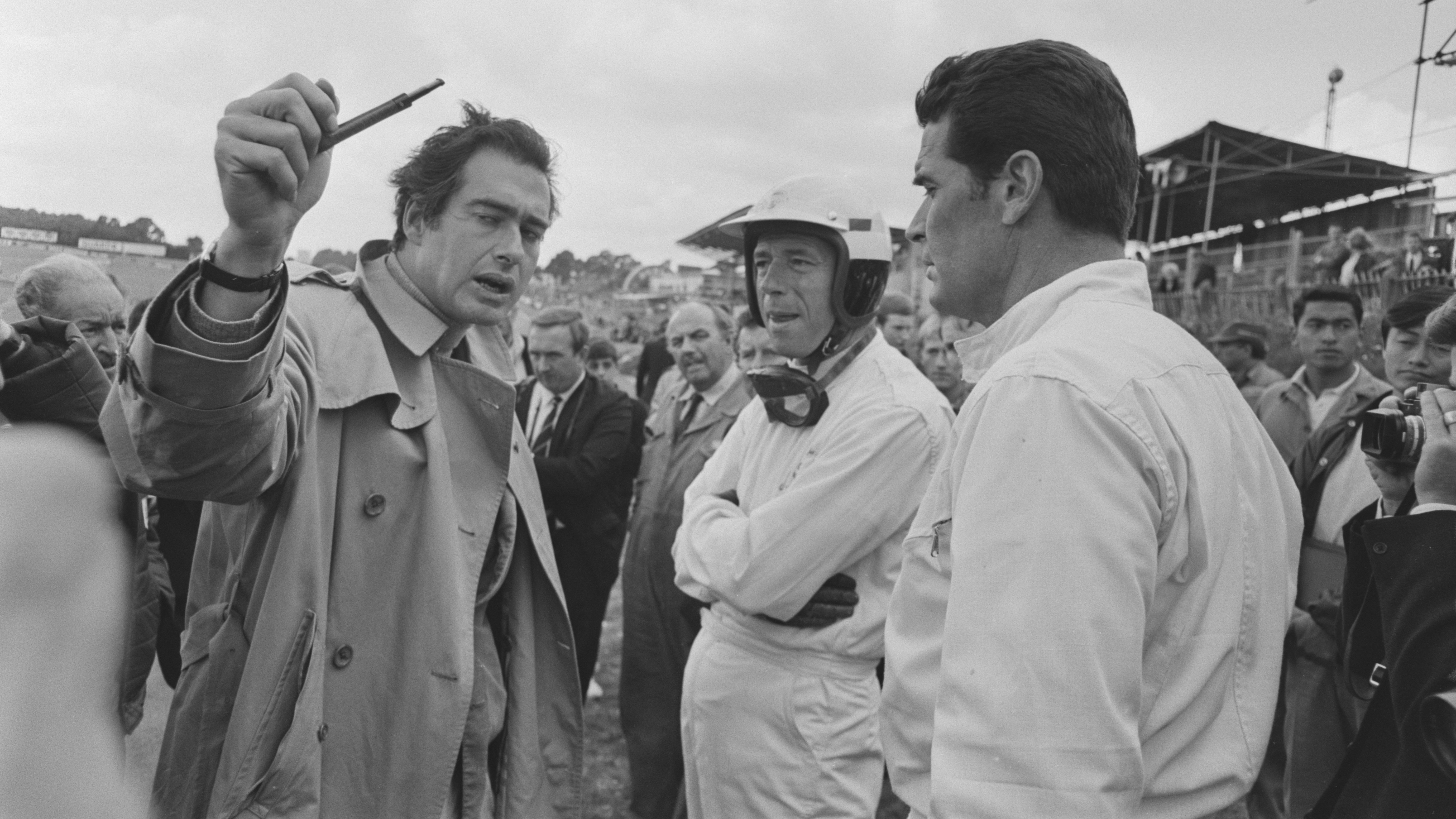 On location at Brands Hatch days after the British Grand Prix, Frankenheimer talks to actors Yves Montand and James Garner, July 1966.