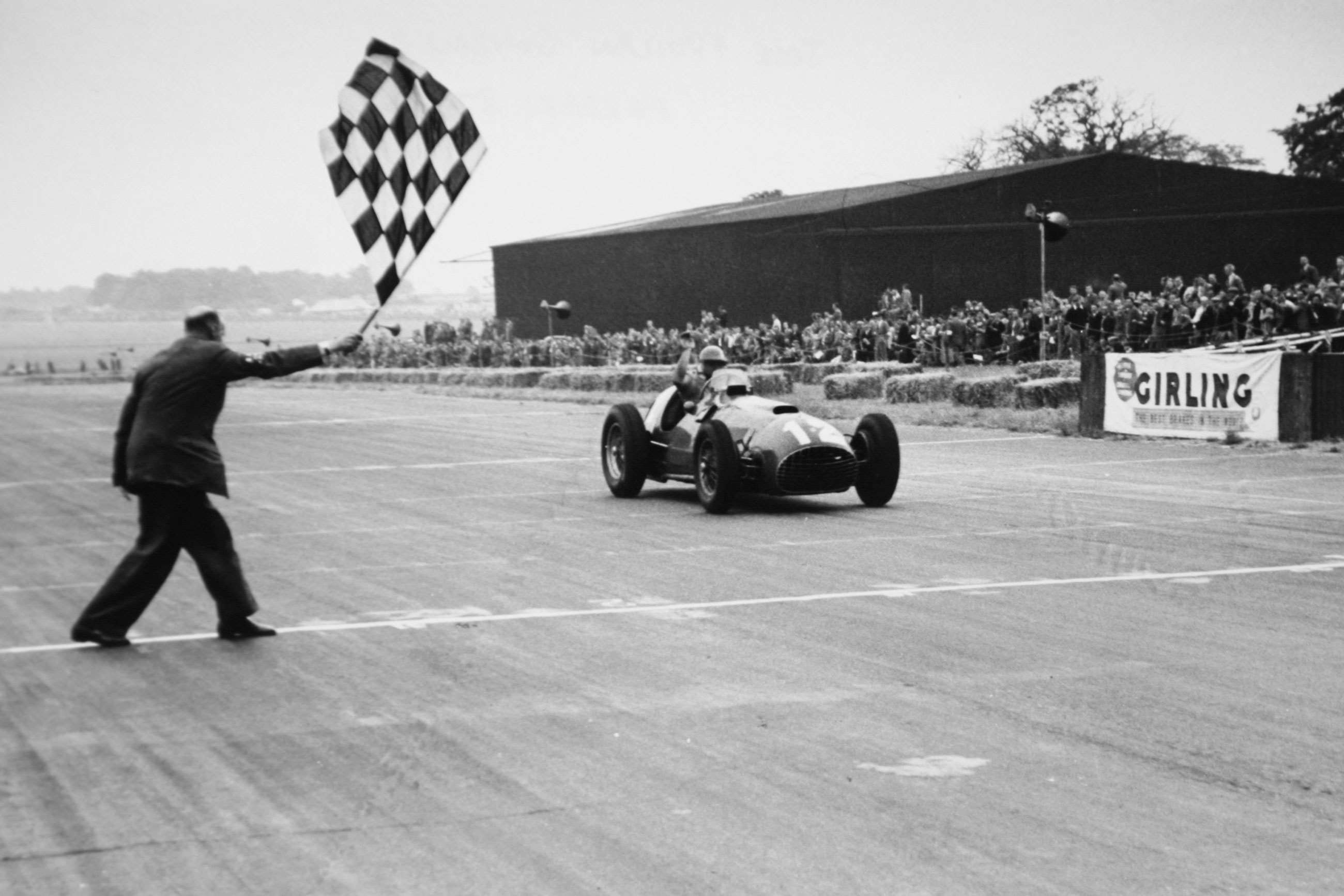 José Froilán González cruzando la meta como ganador del Gran Premio de Gran Bretaña de 1951 en Silverstone