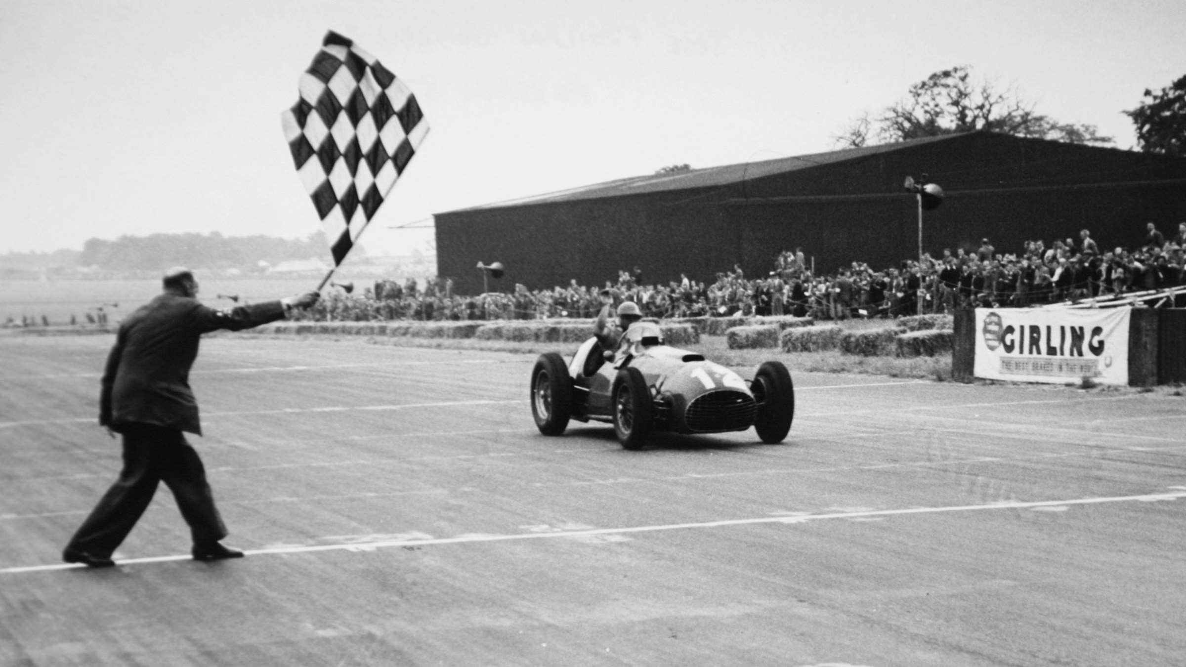 José Froilán González cruzando la meta como ganador del Gran Premio de Gran Bretaña de 1951 en Silverstone