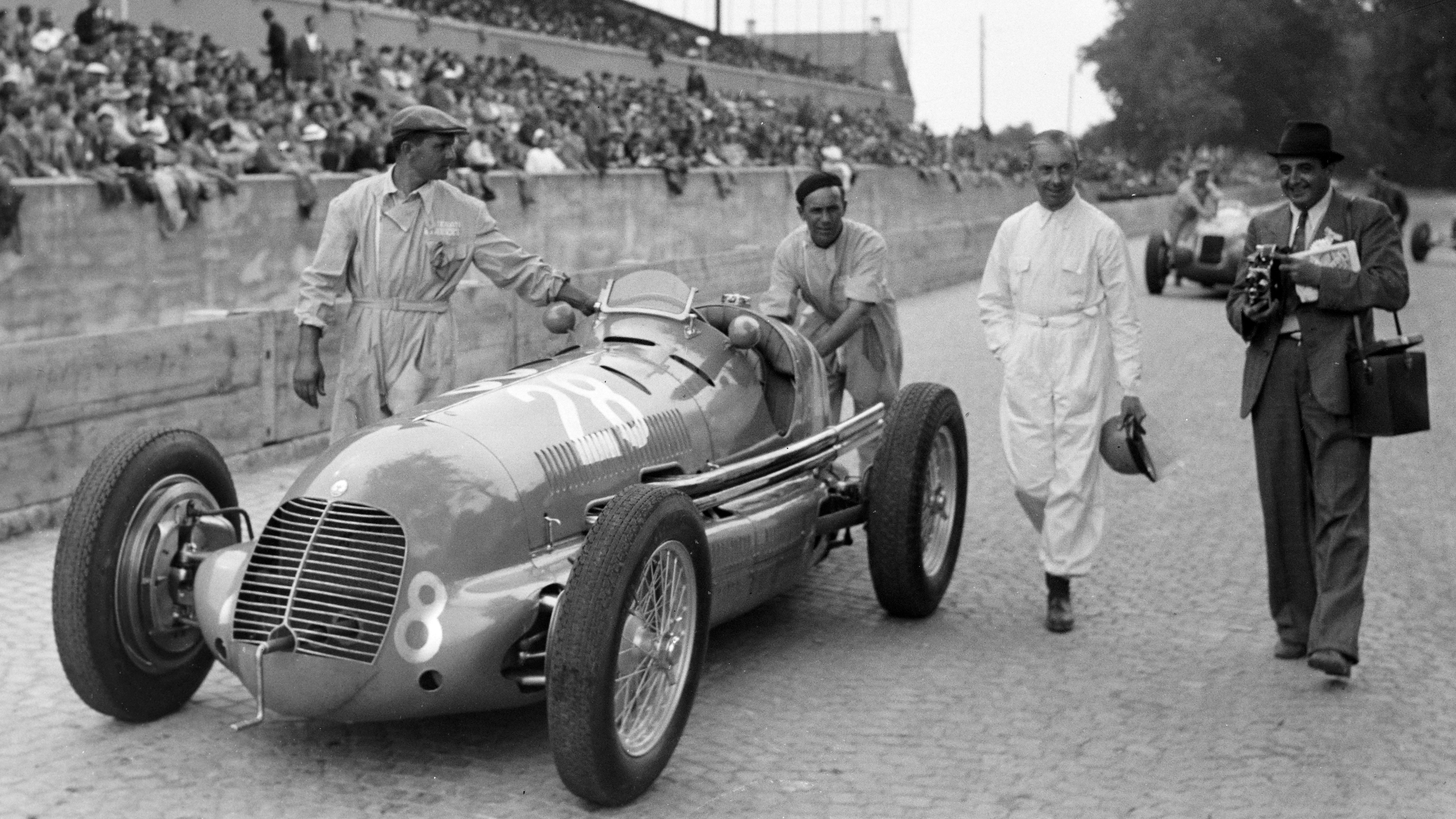René Dreyfus walks besides his Maserati 8CTF at the Swiss Grand Prix at Bremgarten, August 1939.