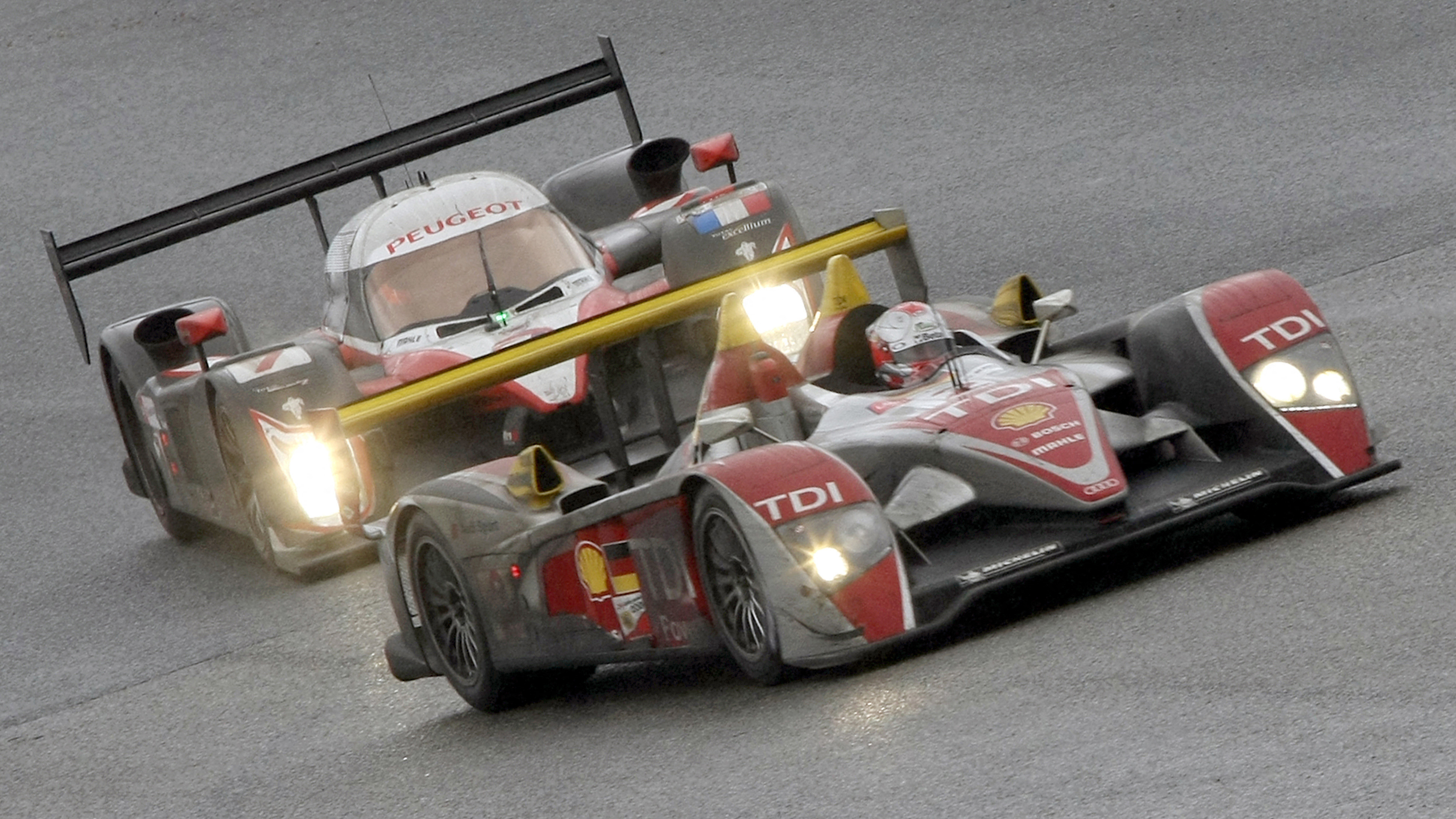 The Audi of Rinaldo Capello leads Jacques Villeneuve's Peugeot on its way to victory at the 2008 Le Mans 24 Hours. 