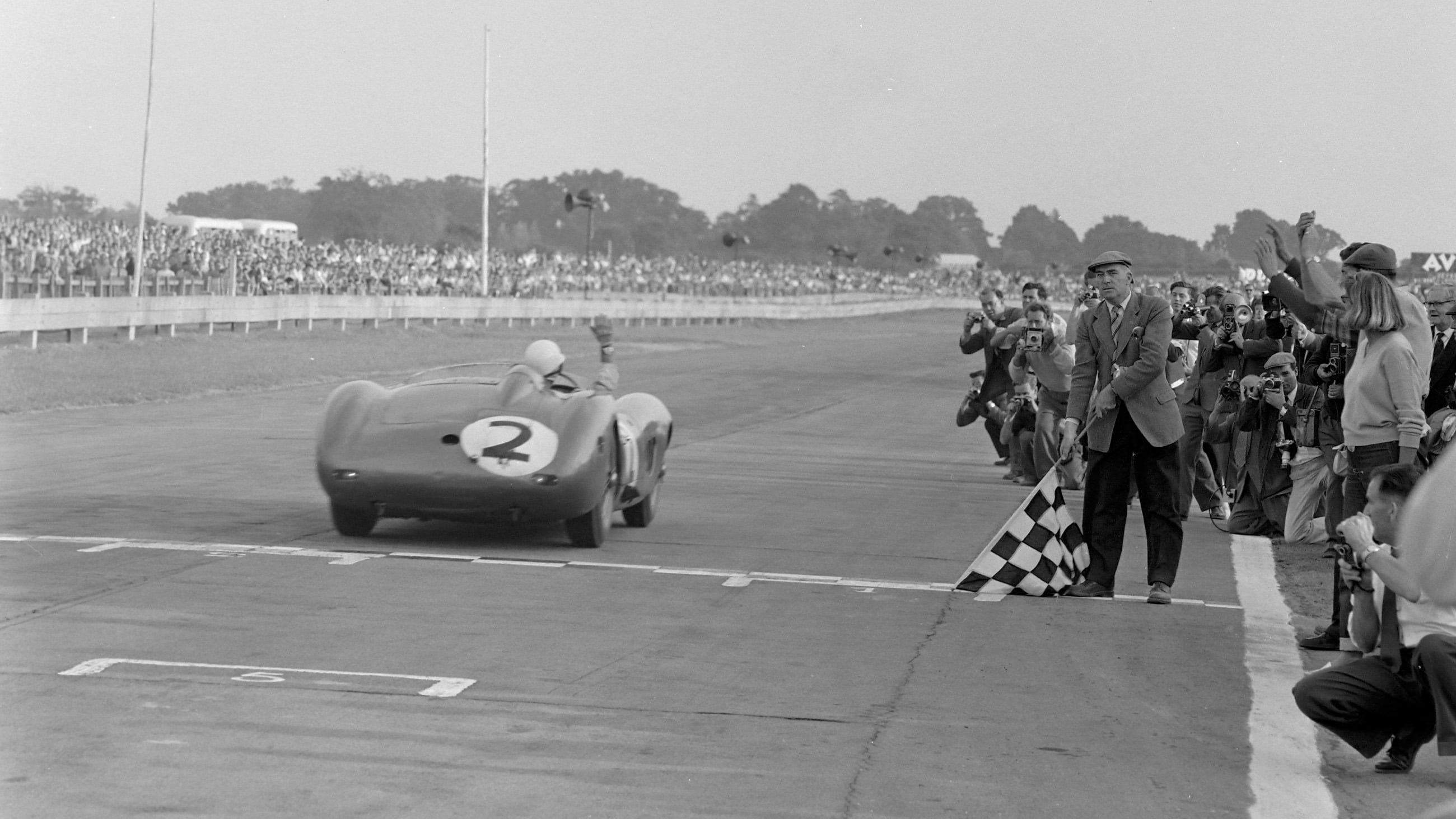 The Carroll Shelby/Jack Fairman/Stirling Moss Aston Martin DBR1 takes the chequered flag in the Tourist Trophy at Goodwood on 5th September 1959