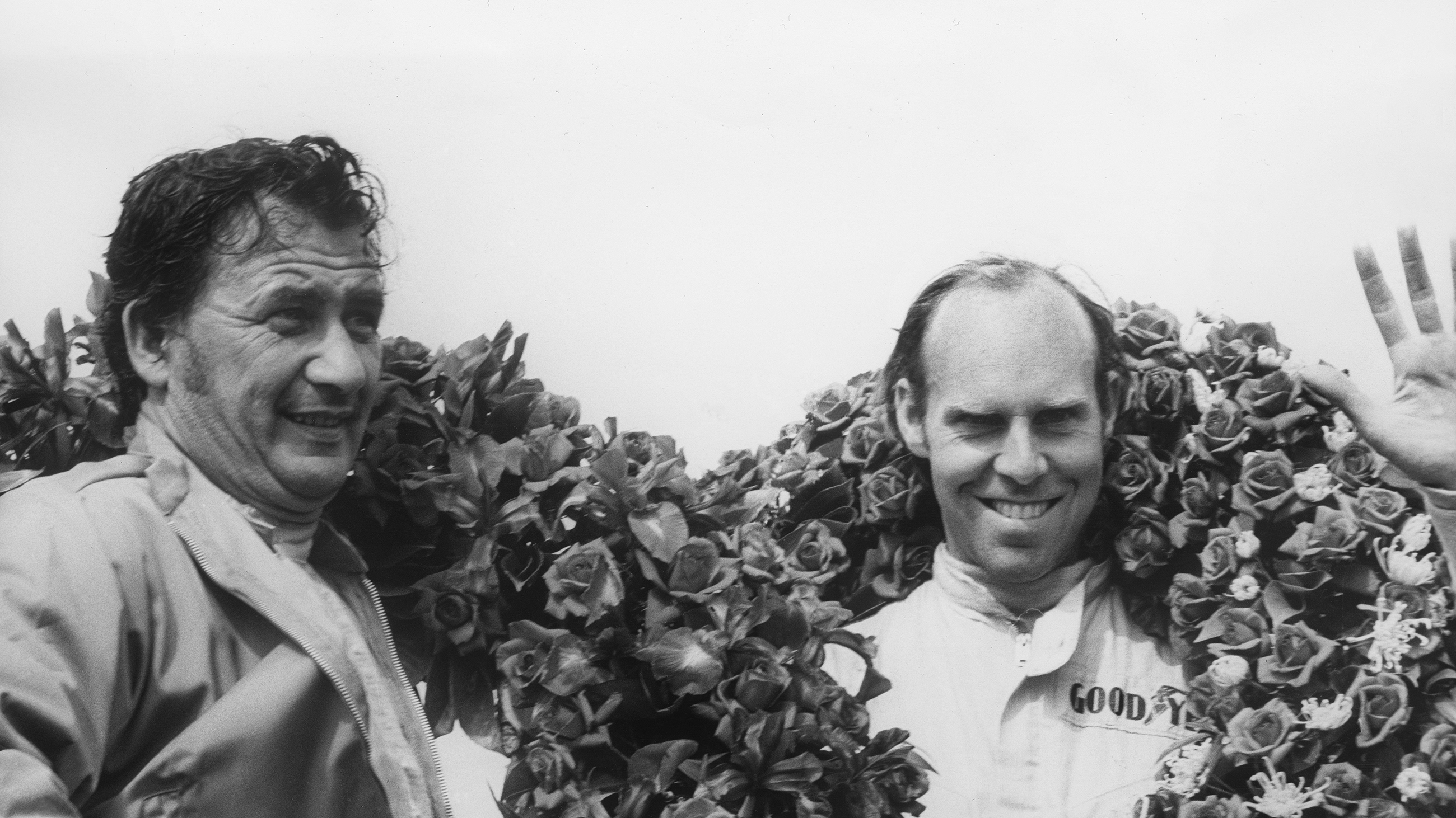 Hans Herrmann and Richard Attwood celebrate on the podium after winning the 1970 Le Mans 24 Hours with Porsche.
