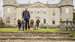 Picture of The Duke of Richmond with four Poodles in front of Goodwood House
